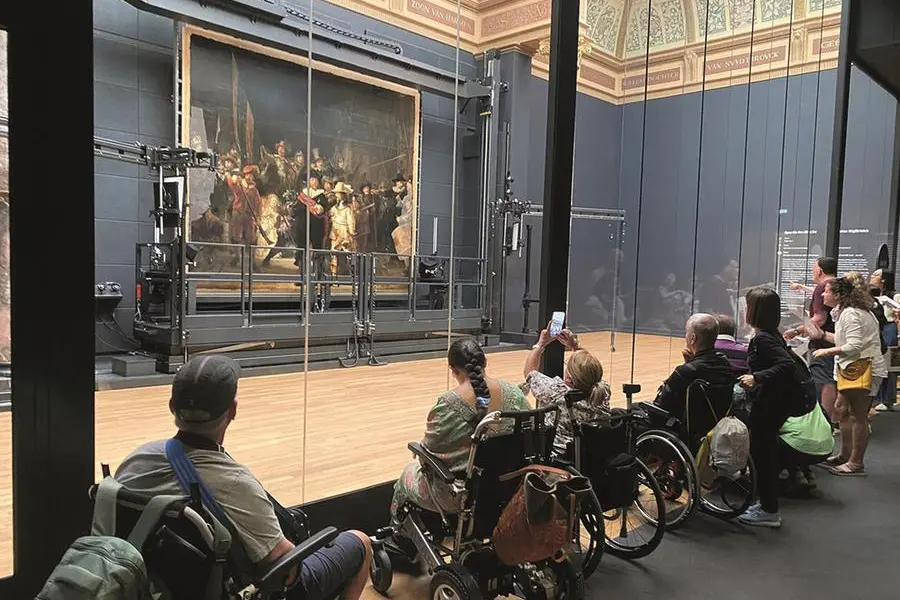 Un gruppo di turisti con sedia a ruote al Rijksmuseum di Amsterdam