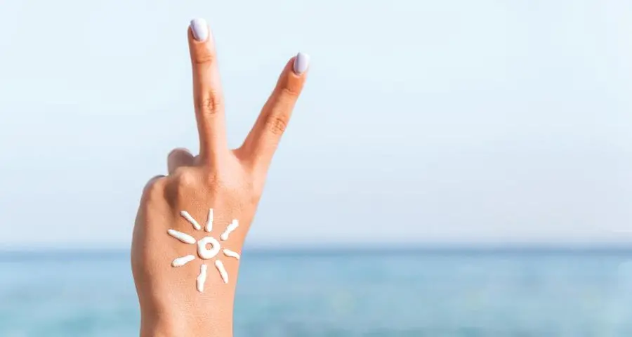 Crema solare su viso e collo: vale la regola delle due dita